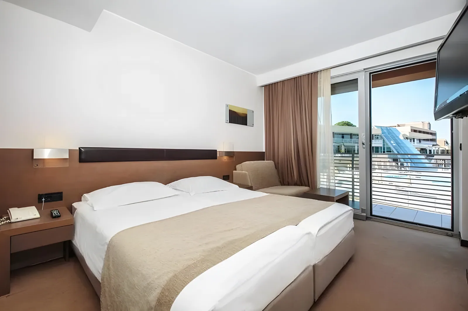 Soba sa bračnim krevetom, pogledom sa balkona i modernim nameštajem · Istra - Poreč - Leto 2026. - Hotel Molindrio Plava Laguna 4*