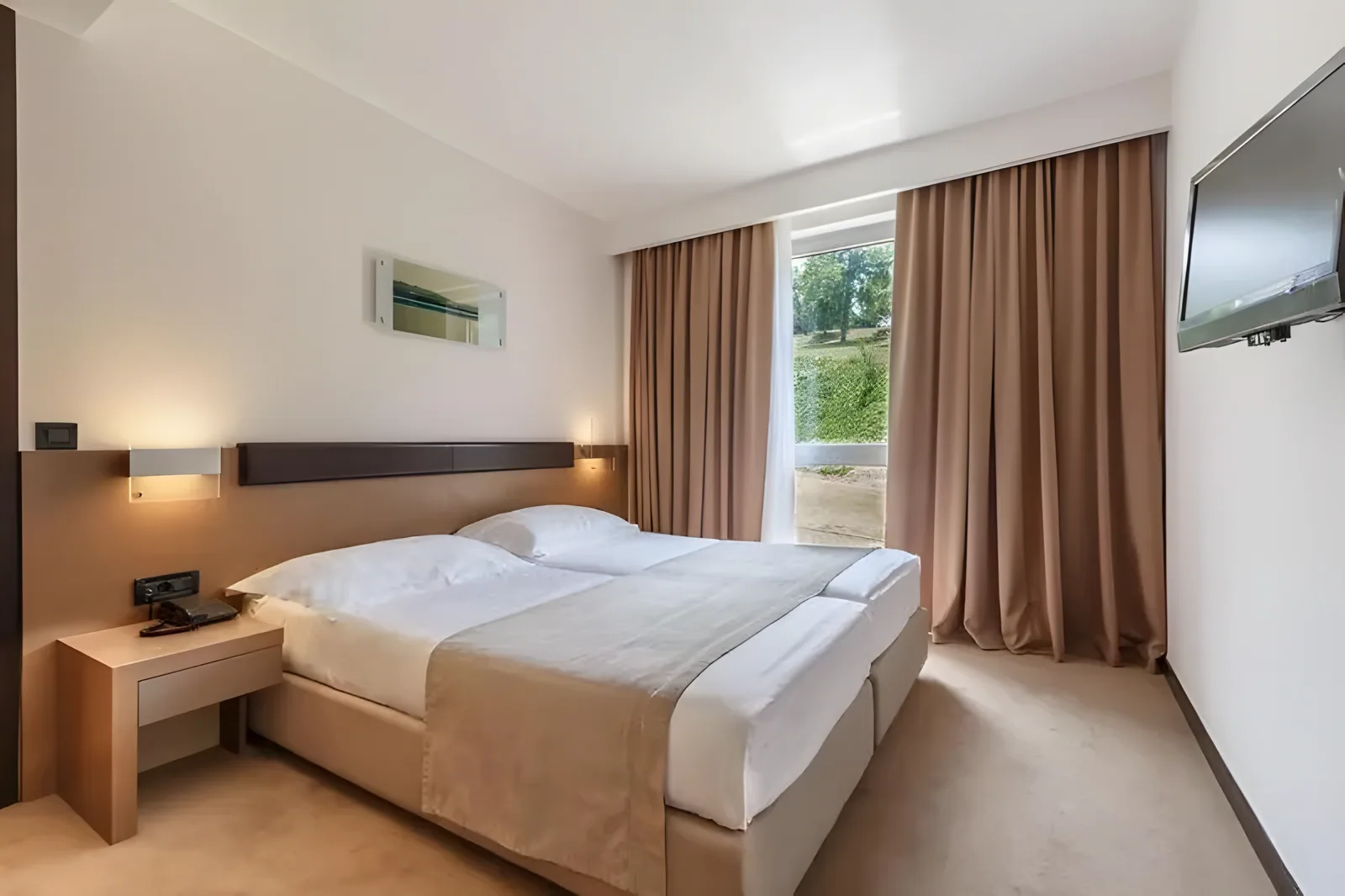 Spavaća soba sa bračnim krevetom, prozorom i savremenim dizajnerskim detaljima · Istra - Poreč - Leto 2026. - Hotel Molindrio Plava Laguna 4*