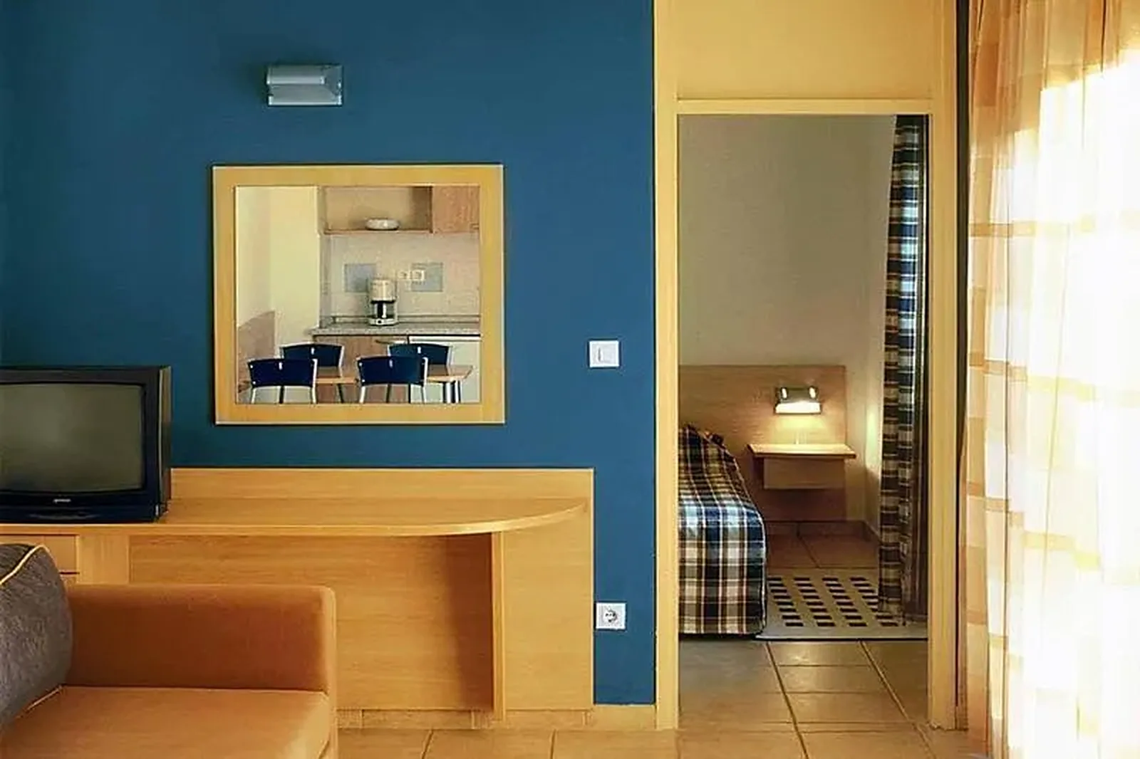 Dnevni boravak sa plavim zidom, drvenim nameštajem i prolazom do spavaće sobe · Istra - Poreč - Leto 2026. - Hotel Valamar Diamant Residense 3*