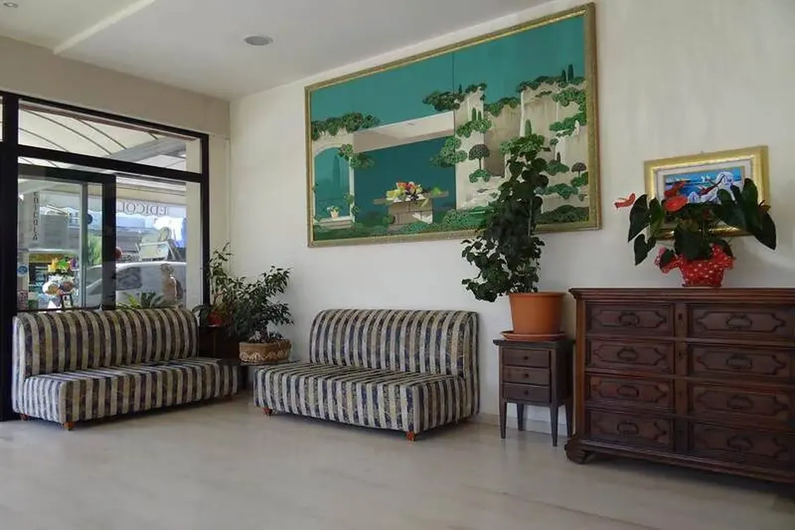 Lobi sa prugastim foteljama, biljkama i dekorativnim motivom predela · Hotel Blumen, Viserba