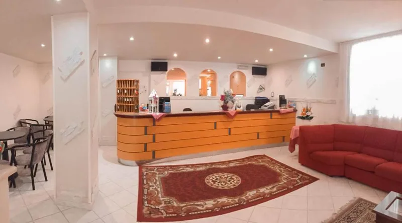 Recepcija sa drvenim pultom i tepihom · Hotel Admiral, Cervia - Pinarella