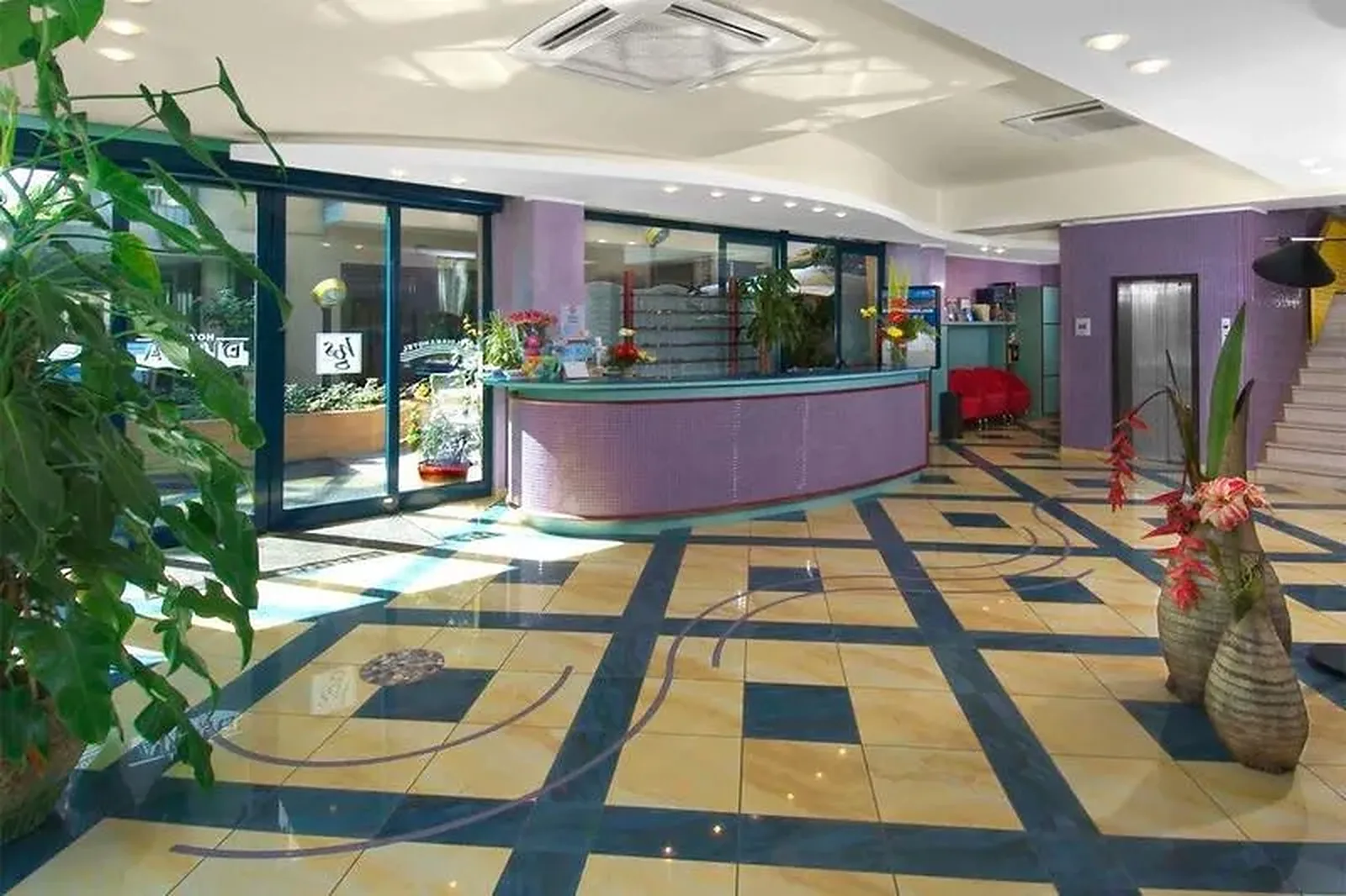 Reception hall with purple accent wall and geometric floor pattern · Hotel Diana, Bellaria - Igea Marina