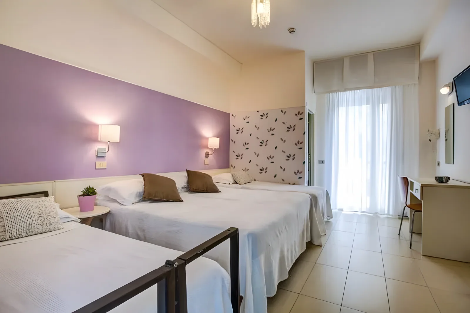 Soba sa ljubičastim akcentnim zidom i više pojedinačnih kreveta · Hotel Konrad, Marebello