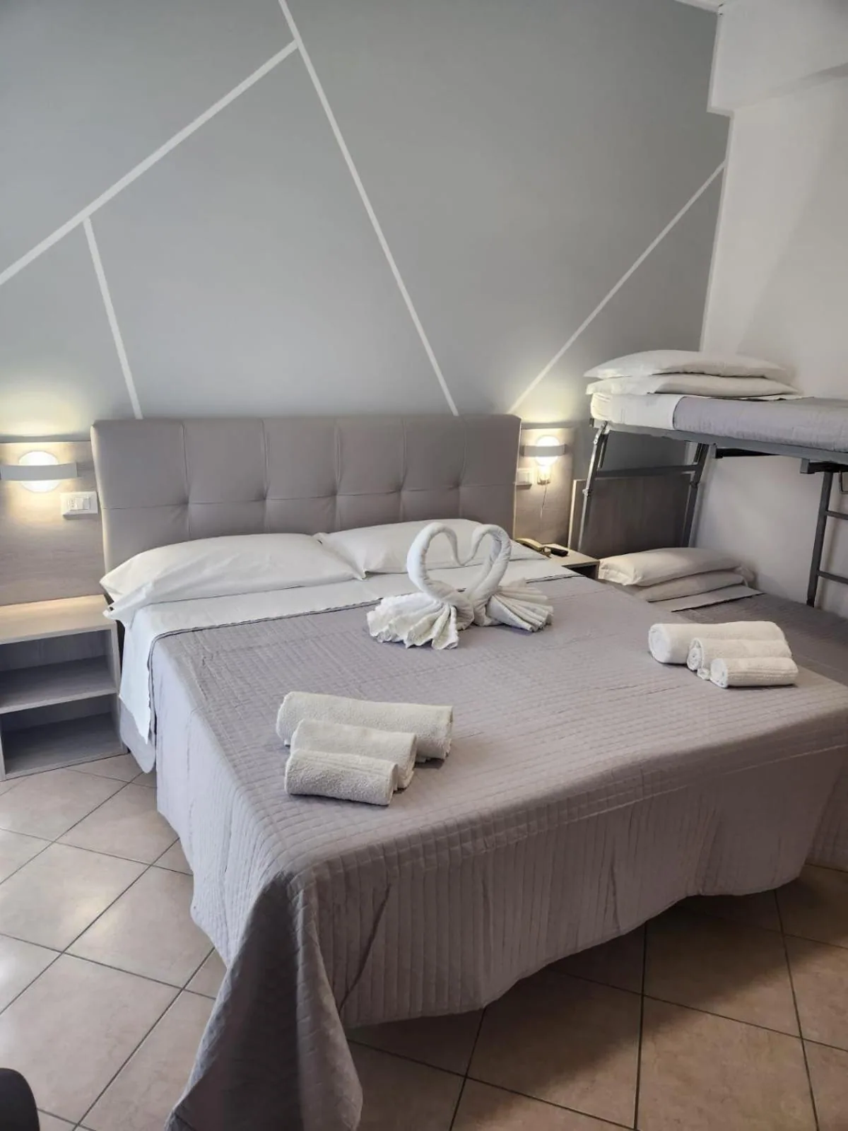 Soba sa krevetom i krevetom na sprat u pozadini · Hotel Liu, Marebello