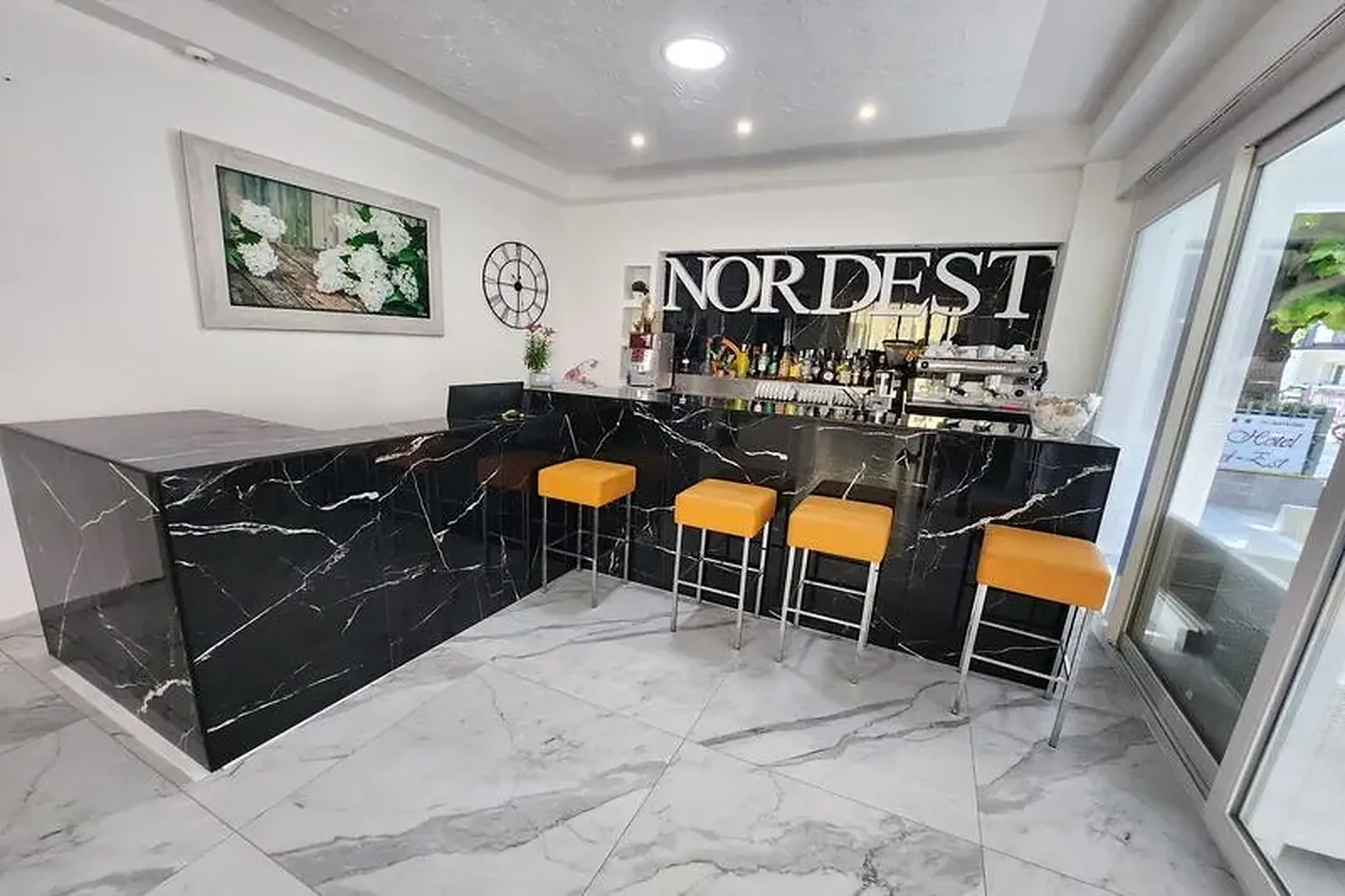Šanak sa logom Nordest i narandžastim barskim stolicama · Hotel Nord Est, Riccione