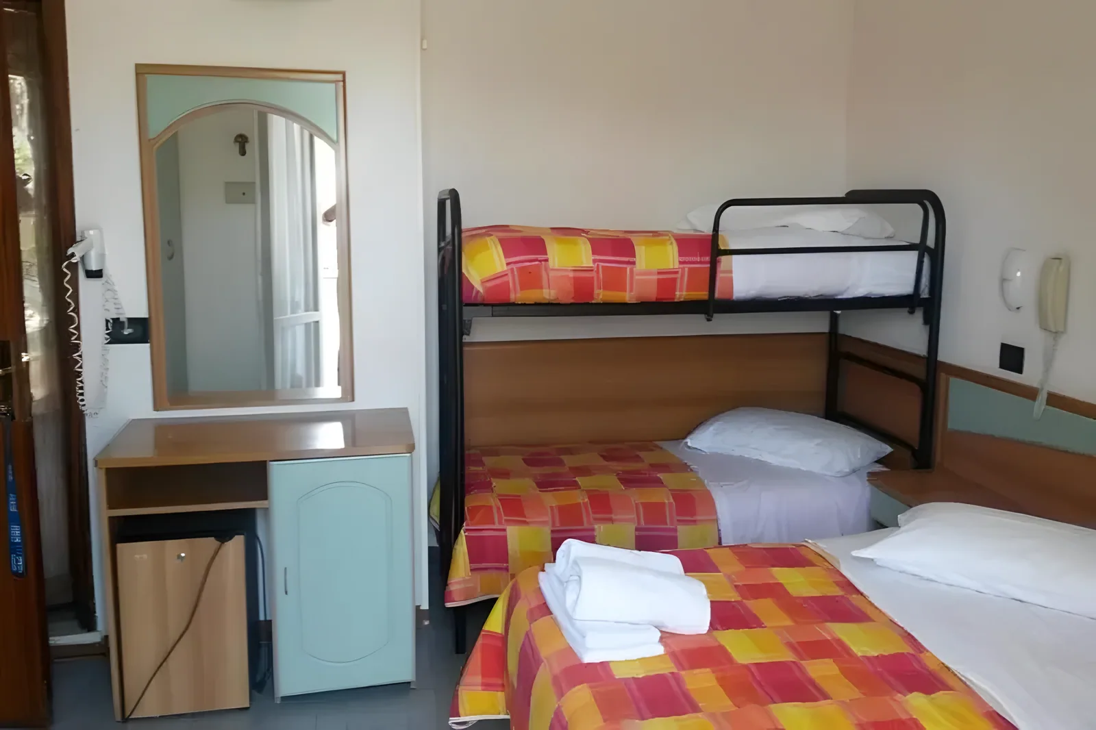 Kreveti na sprat sa ogledalom i toaletnim stočićem · Hotel Orchidea, Casenatico