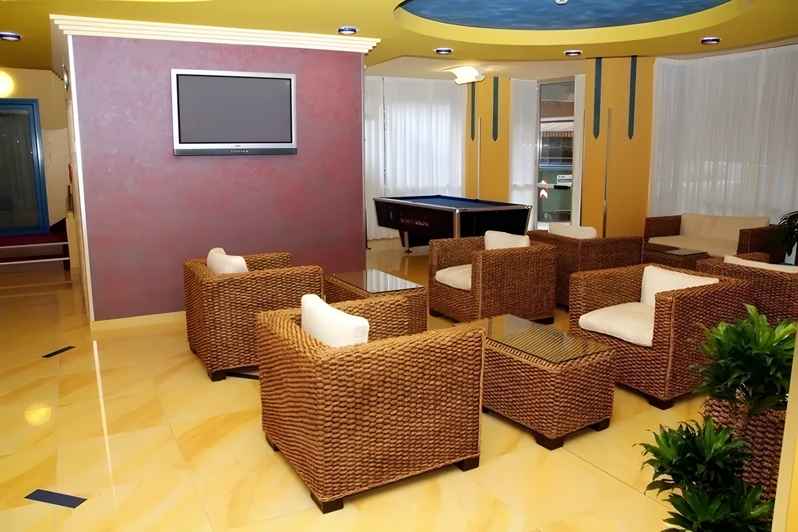 Zajednički prostor sa pletenim foteljama, TV ekranom i klavirom · Hotel Senior, Cattolica
