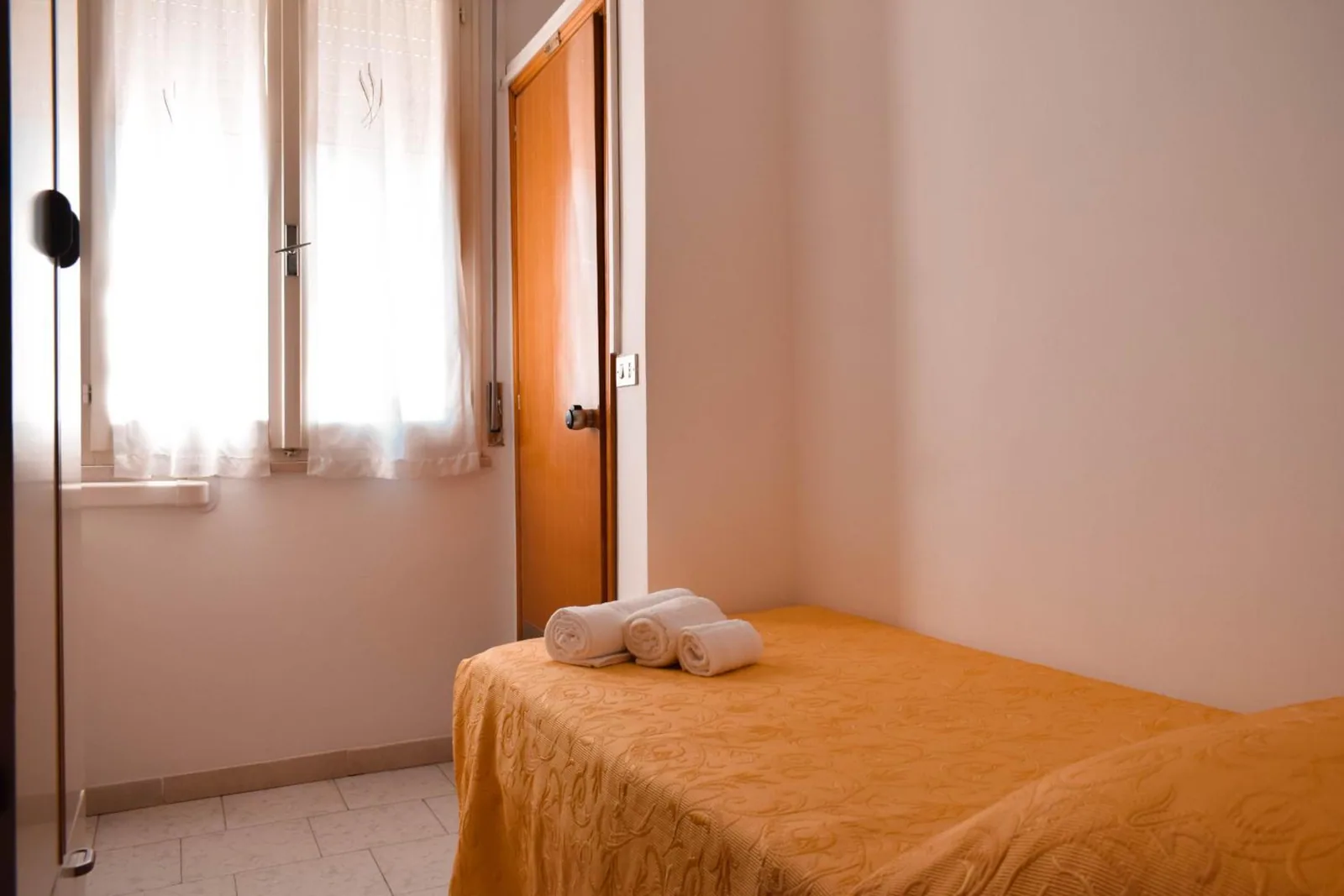 Krevet sa peškirima pored prozora · Hotel Zeus, Cervia - Pinarella