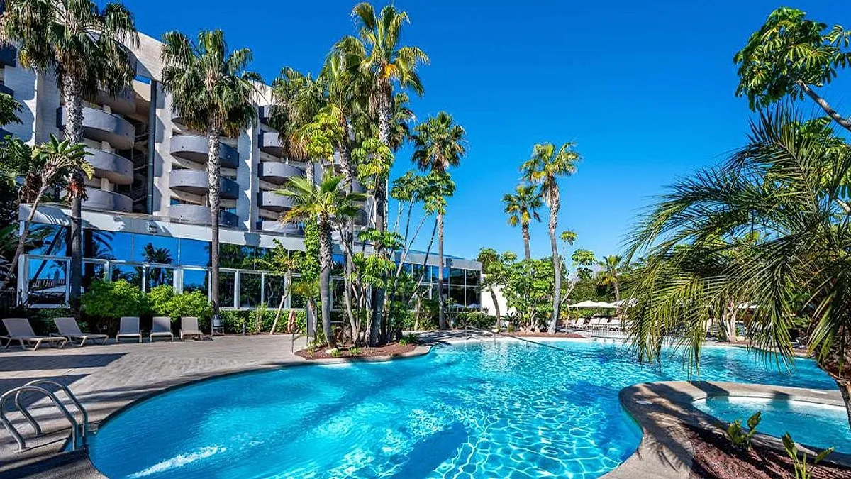 Spoljni bazen okružen palmama i zgradom hotela · Albir Playa Hotel & Spa, El Albir