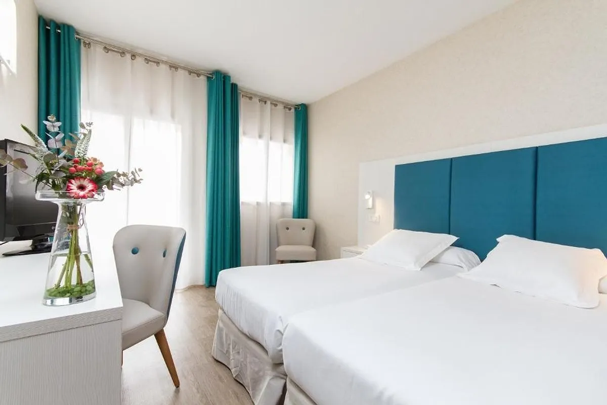 Room with two beds and a turquoise headboard · Hotel Castilla Alicante, Alicante