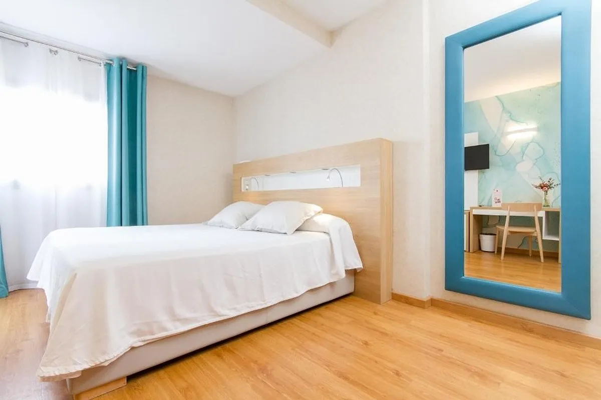 Room with a double bed and a large mirror in a turquoise frame · Hotel Castilla Alicante, Alicante