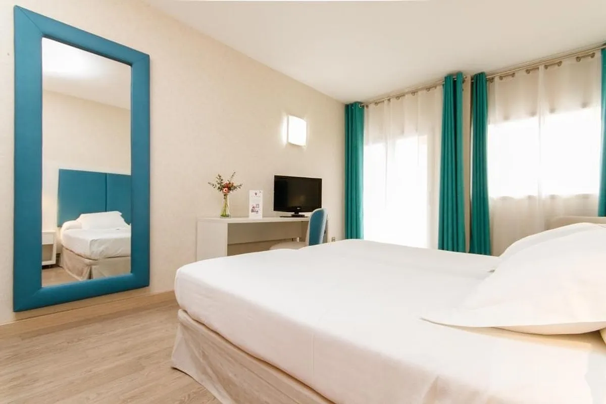 Room with a bed, a mirror and a desk · Hotel Castilla Alicante, Alicante