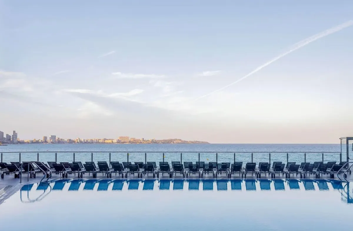 Bazen sa nizom ležaljki na terasi i pogledom na more · Meliá Alicante, Alikante