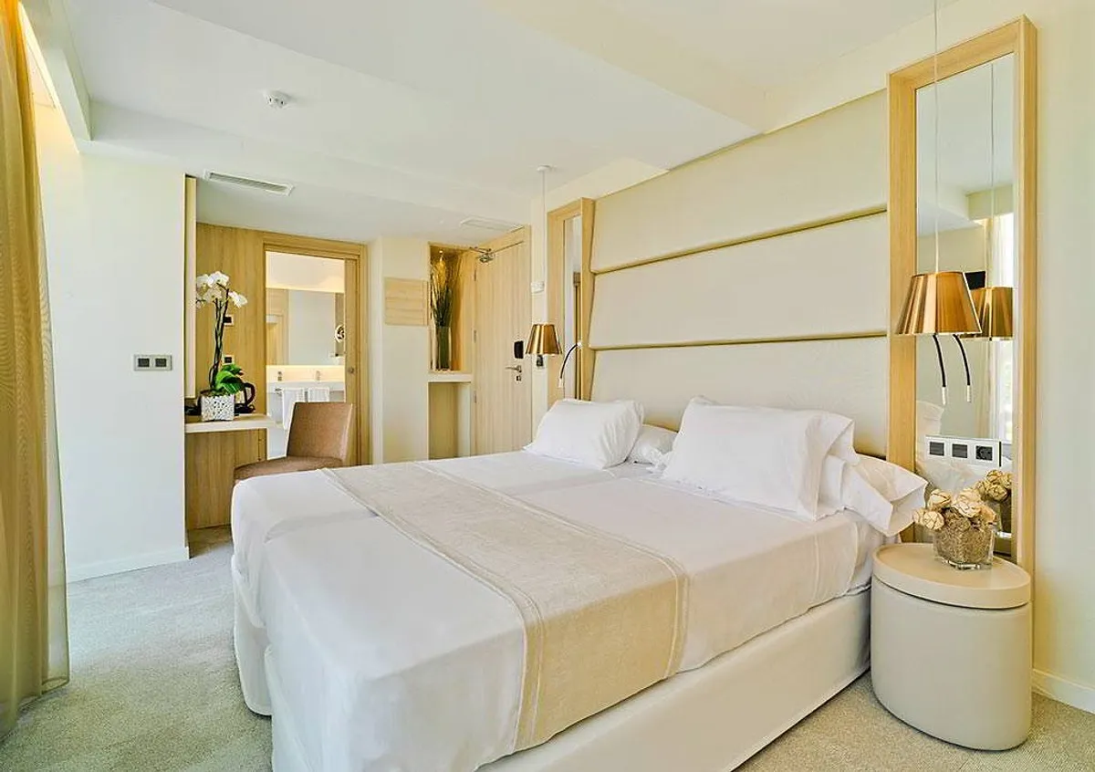 Soba sa bračnim krevetom i svetlim drvenim zidom · Hotel Don Pancho, Benidorm