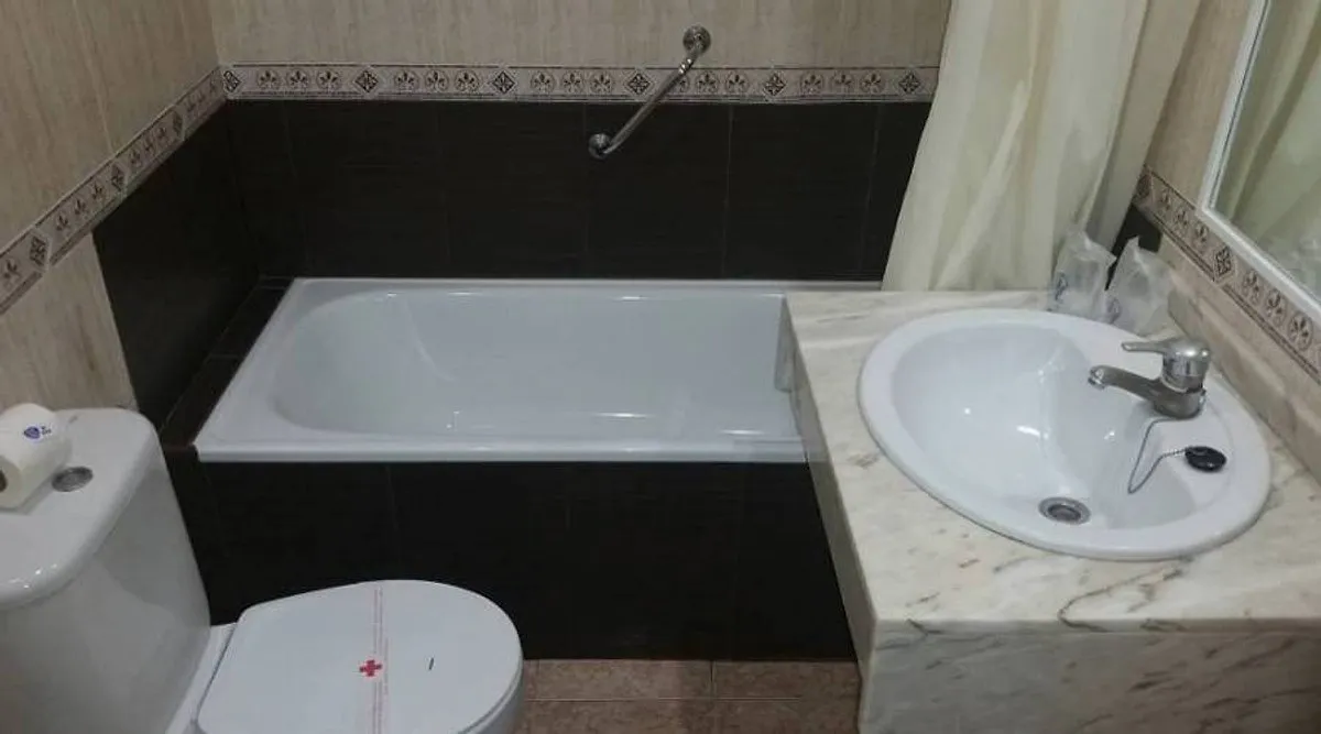 Kupatilo sa kadom, belim umivaonikom i tamnim pločicama · Hotel Mont-Park, Benidorm