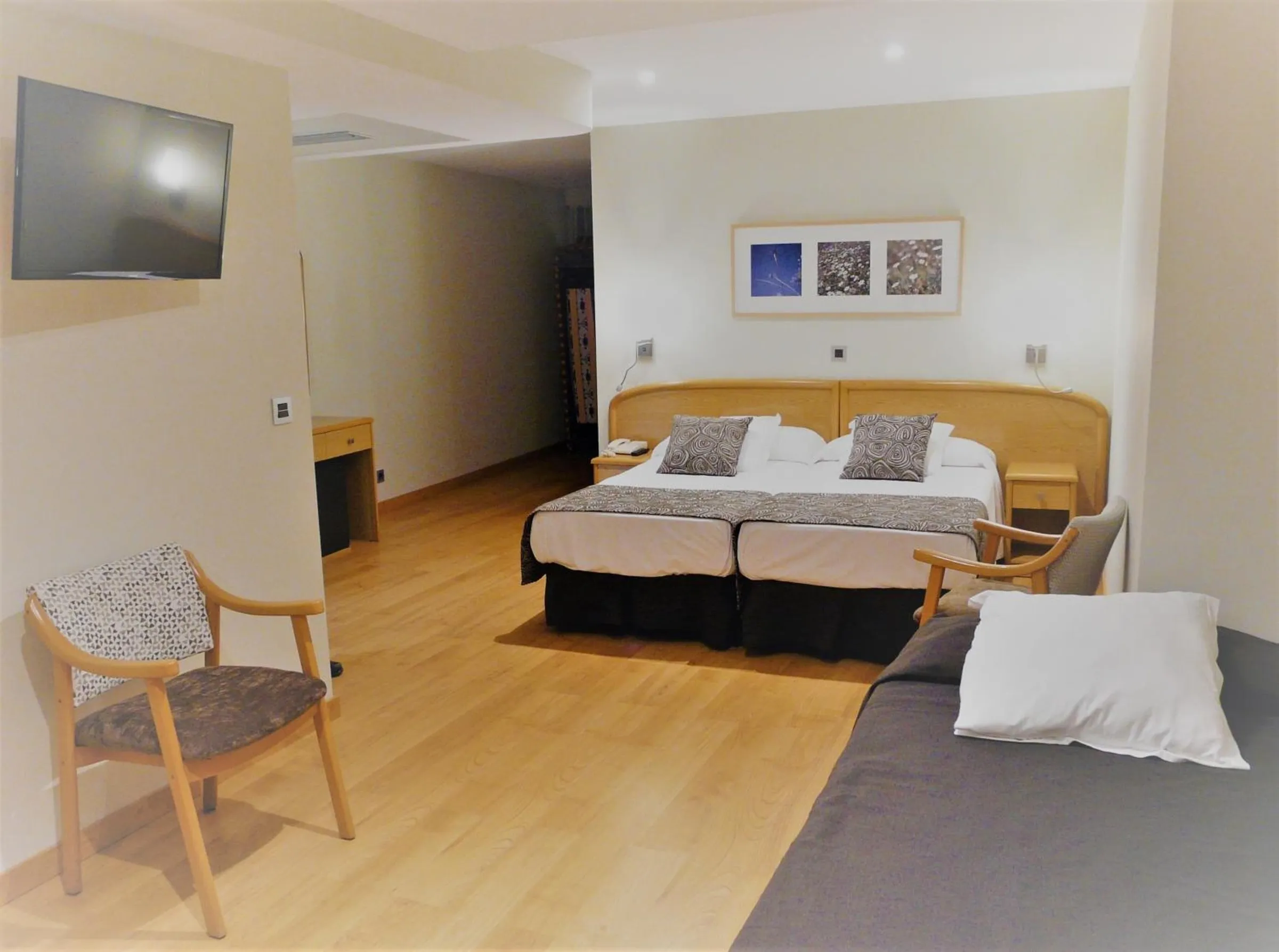Soba sa dva kreveta, drvenim podom i foteljom · Hotel Tanit, Benidorm