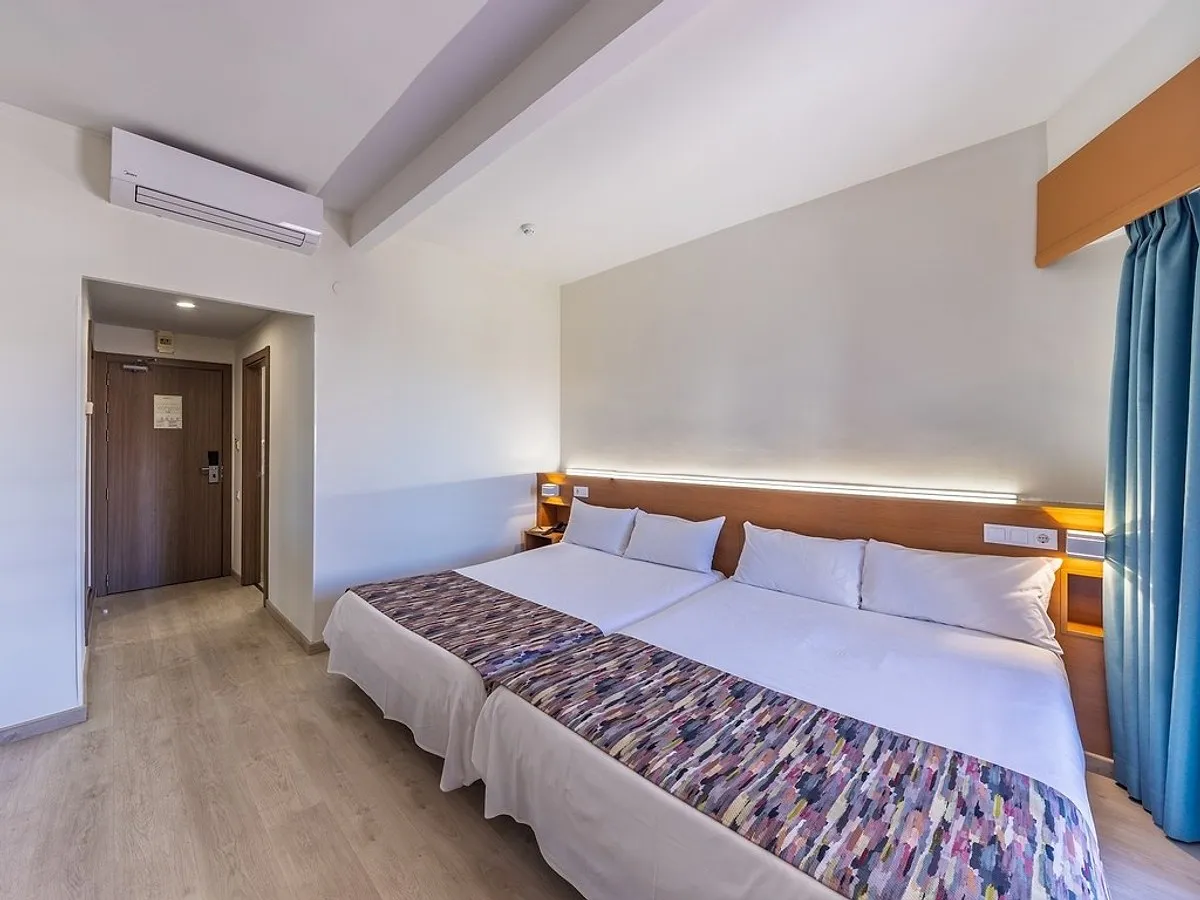 Svetla soba sa dva kreveta i plavim zavesama · Hotel Alone, Finestrat
