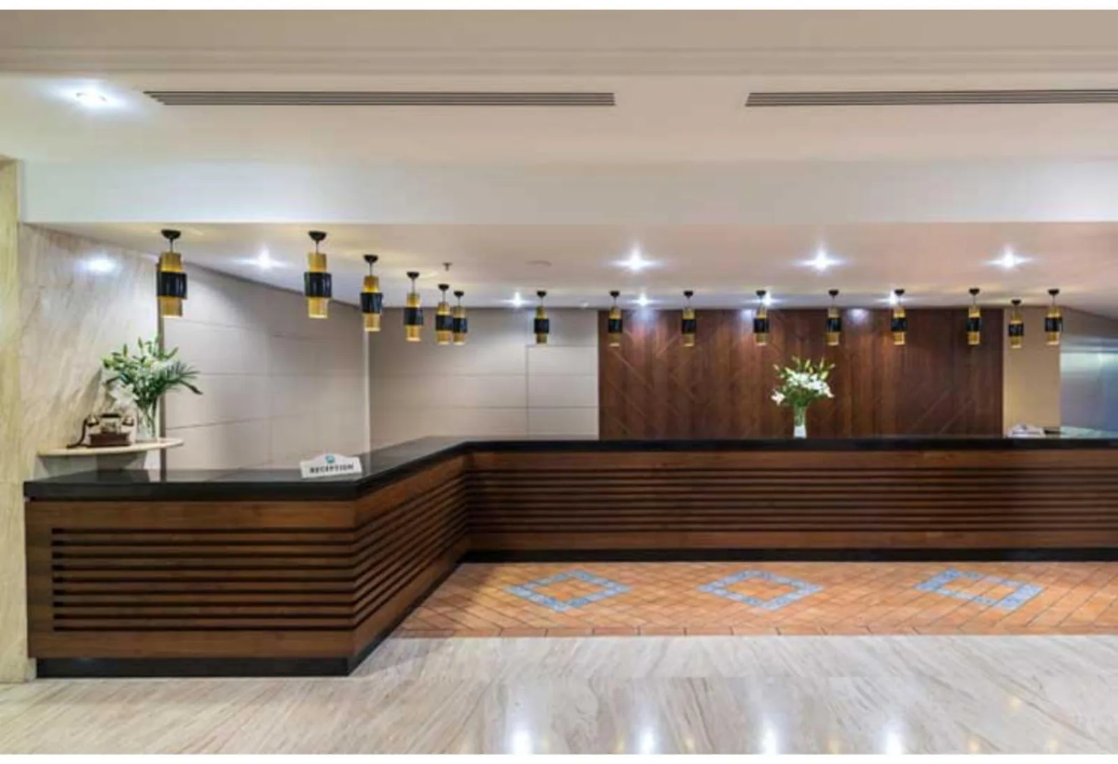 Recepcija sa drvenim pultom i cvećem · Ma Biche Kemer By Werde Hotels, Kemer